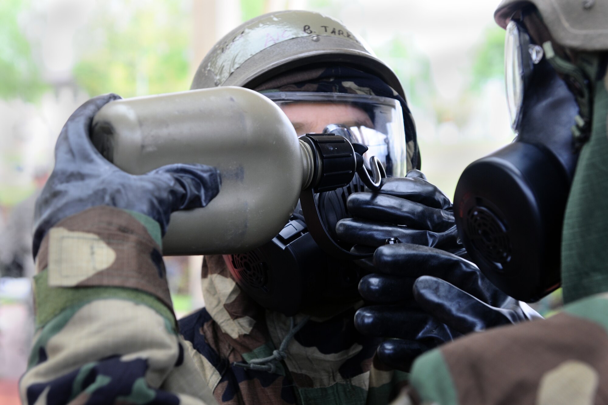 SPANGDAHLEM AIR BASE, Germany – An Airman from the 52nd Fighter Wing drinks water through an M50 joint service general purpose gas mask during individual core competency skills training at the outdoor basketball court here May 7. The training evaluated Airmen on their combat readiness skills such as M-4 assault rifle weapons knowledge; self-aid buddy care; and chemical, biological, radiological, nuclear, and high-yield explosive preparedness. The training ensures the 52nd Fighter Wing is able to provide combat power to the current fight. (U.S. Air Force photo by Airman 1st Class Dillon Davis/Released)