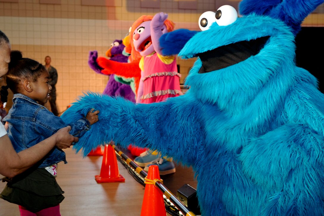 Three-year-old Aubrey Smith says “hello” to Cookie Monster during the 2011 Joining Forces: Sesame Street and USO Special Event show at the Langley Air Force Base, Va., youth center, May 7, 2012. During the show, children were able to dance with and greet some of the characters. (U.S. Air Force photo by Senior Airman Wesley Farnsworth/Released)