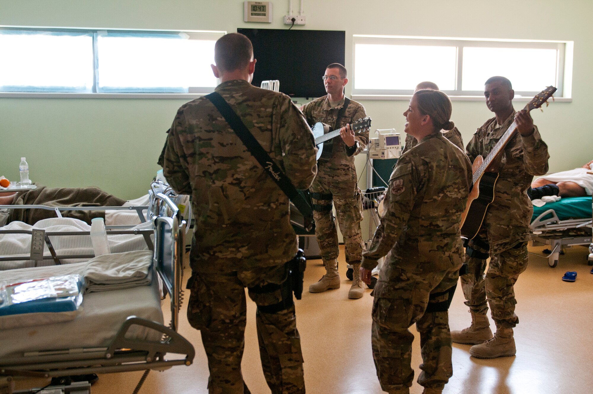 Members of the U.S. Air Forces Central Band Nightwing sing to patients at the Role Three Hospital May 2, 2012 at Kandahar Airfield, Afghanistan. During this visit, the band would play music for wounded warriors who are recovering after combat and non-combat related injuries. (U.S. Air Force photo by Staff Sgt. David Salanitri/Released)