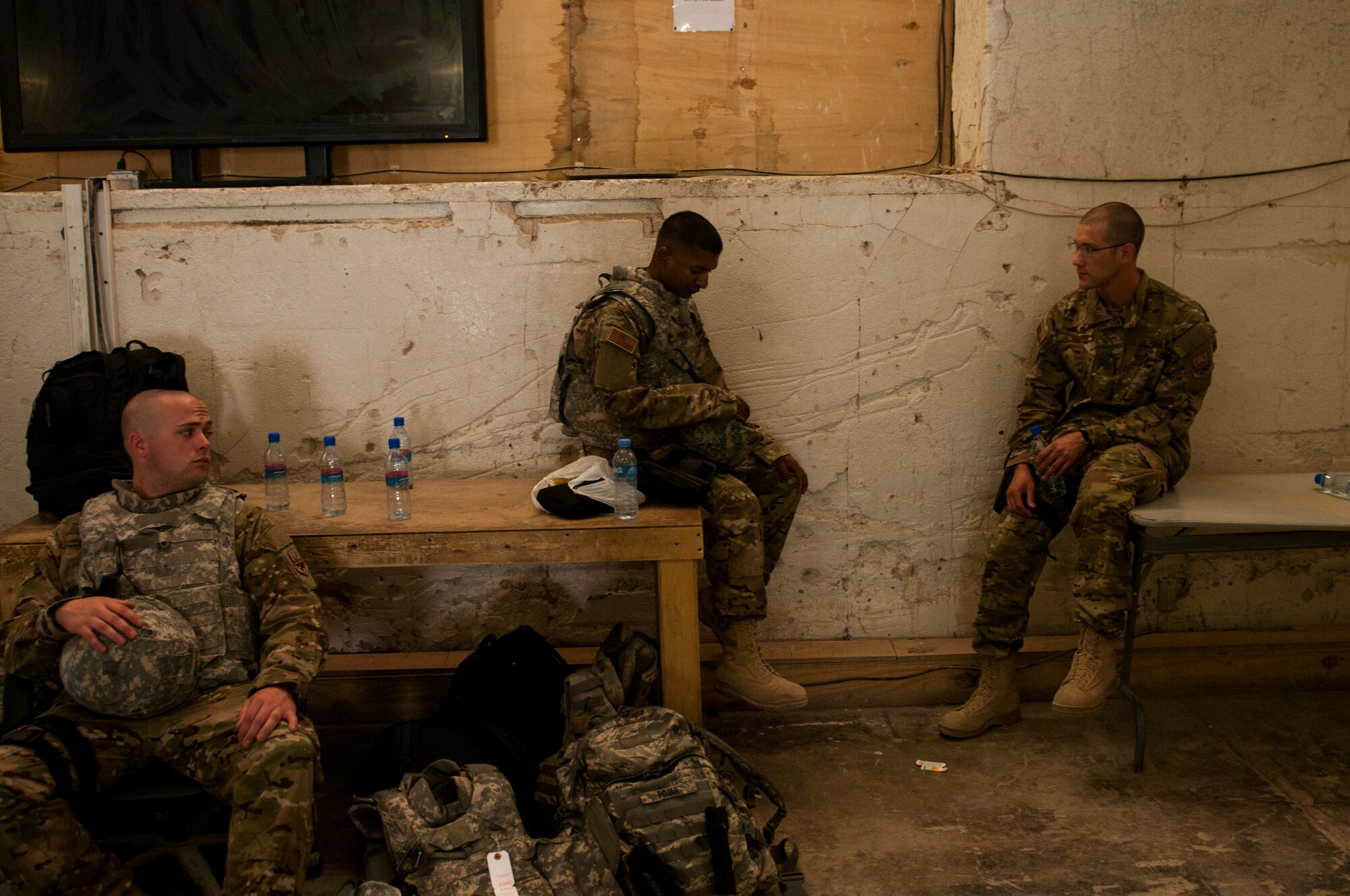 From left, Airmen 1st Class Dave Wilson, Ryan Persaud and Lee Heerspink, members of the U.S. Air Forces Central Band Nightwing, wait to inprocess May 1, 2012 at Kandahar Airfield Afghanistan. This was the first stop on the band's tour throughout Afghanistan, playing for U.S. and coalition service members. (U.S. Air Force photo by Staff Sgt. David Salanitri/Released)