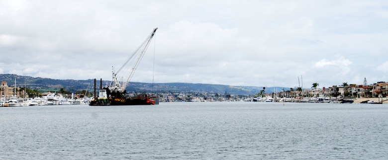 A clamshell dredge begins a five-month project May 2, 2012 to remove up to 350,000 cubic yards of material from the federal channel in Newport Harbor, Calif. The Port of Long Beach will use about one-third of the dredged material for its middle harbor redevelopment project.