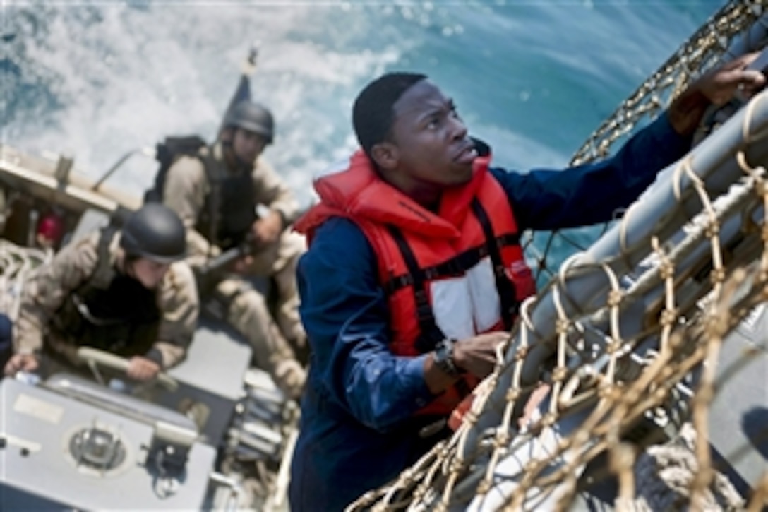 U.S. Navy Seaman Julius McGowan climbs down to a rigid-hull inflatable boat during a boarding exercise in the Atlantic Ocean, May 6 2012. McGowan is assigned to the ship-control team aboard the guided-missile destroyer USS Jason Dunham, which is conducting a training exercise in the Atlantic Ocean.