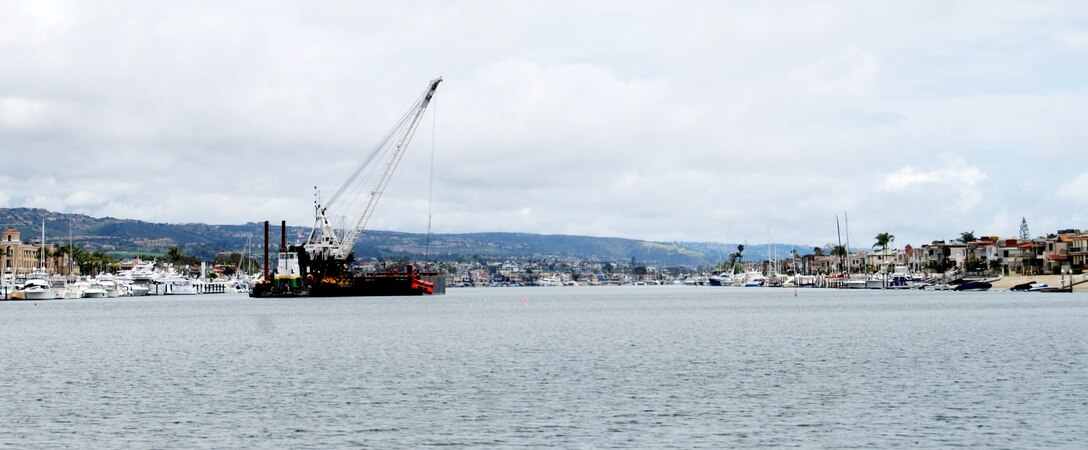 A clamshell dredge begins a five-month project May 2, 2012 to remove up to 350,000 cubic yards of material from the federal channel in Newport Harbor, Calif. The Port of Long Beach will use about one-third of the dredged material for its middle harbor redevelopment project.