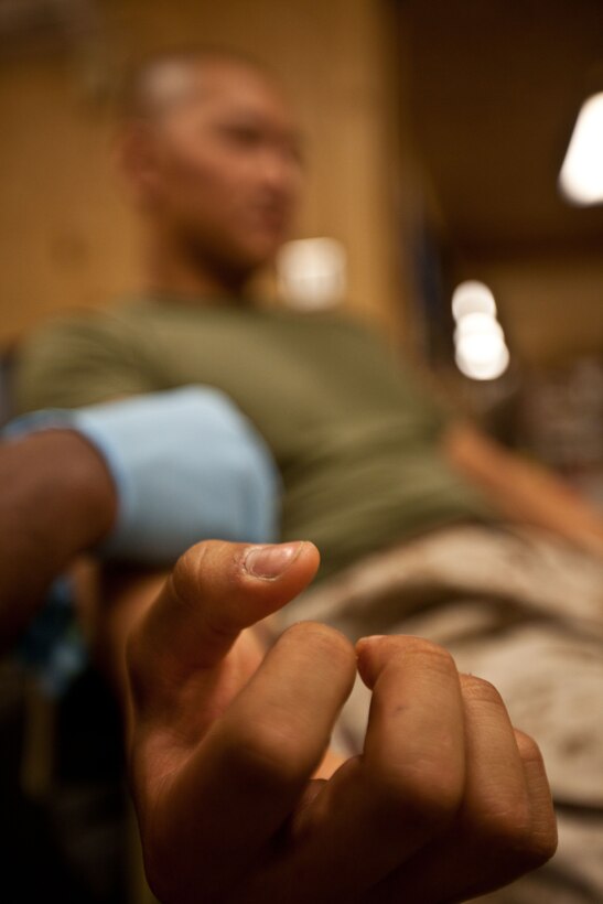 Lance Cpl. Meng Lu donates blood for a dying Afghan Army National soldier waiting in another room at Forward Operating Base Delaram II’s Shock Trauma Platoon, May 8, 2012. The ANA solider stepped on a pressure plate earlier that morning, setting off an improvised explosive device. Because of the donation from Lu and two other donors, doctors expect the soldier to live. The Navy corpsmen, nurses and doctors had to replace nearly all of the patient’s blood because of his injury.