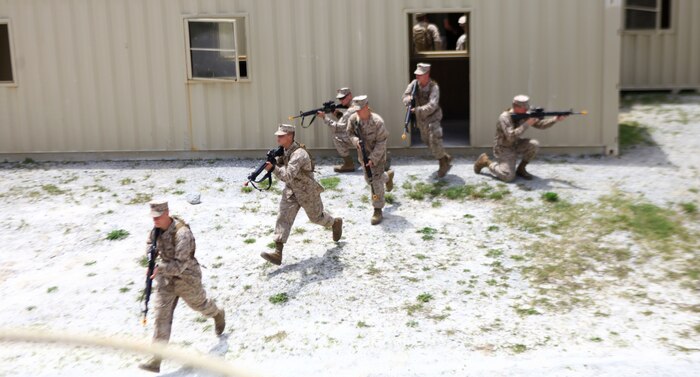 Marines with Bridge Company, 8th Engineer Support Battalion, 2nd Marine Logistics Group exit a building to provide security during a training exercise at a Military Operations in Urban Terrain site aboard Camp Lejeune, N.C., May 9, 2012.  The company spent three days learning patrolling procedures, clearing techniques and communication skills for combat operations.  (U.S. Marine Corps photo by Cpl. Katherine M. Solano)
