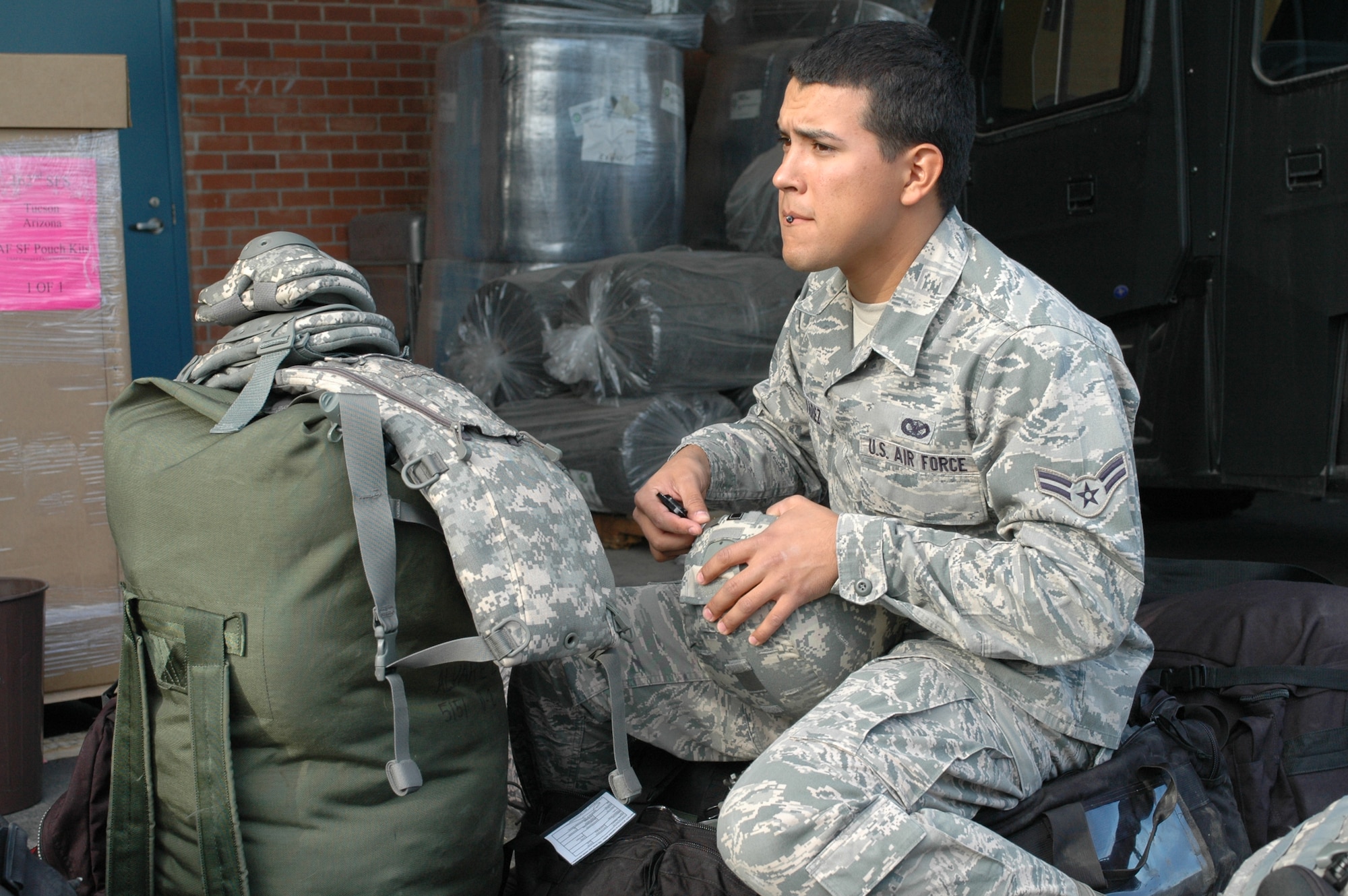 Airman 1st Class Daniel Alvarez prepares his gear at Tucson International Airport for two weeks of pre-deployment training at Fort Bliss, Texas, May 9. Alvarez and 12 of his fellow security forces Airmen assigned to the 162nd Fighter Wing are alternates to deploy to Afghanistan during their current deployment “window.” (U. S. Air Force photo/Maj. Gabe Johnson)