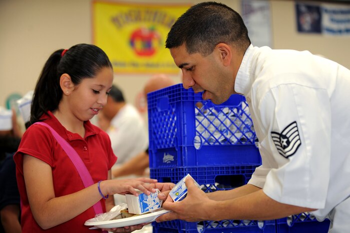 U.S. Air Force Tech Sgt. Justin Franco, 99th Force Support Squadron services craftsman, hands out milk at a Chefs for Kids event, May 3, 2012, at Rex Bell Elementary School in Las Vegas, Nev. Franco is a Chefs for Kids board member and recruits volunteers from Nellis Air Force Base to assist with meals every month.  (U.S. Air Force photo by Staff Sgt. William P.Coleman)  