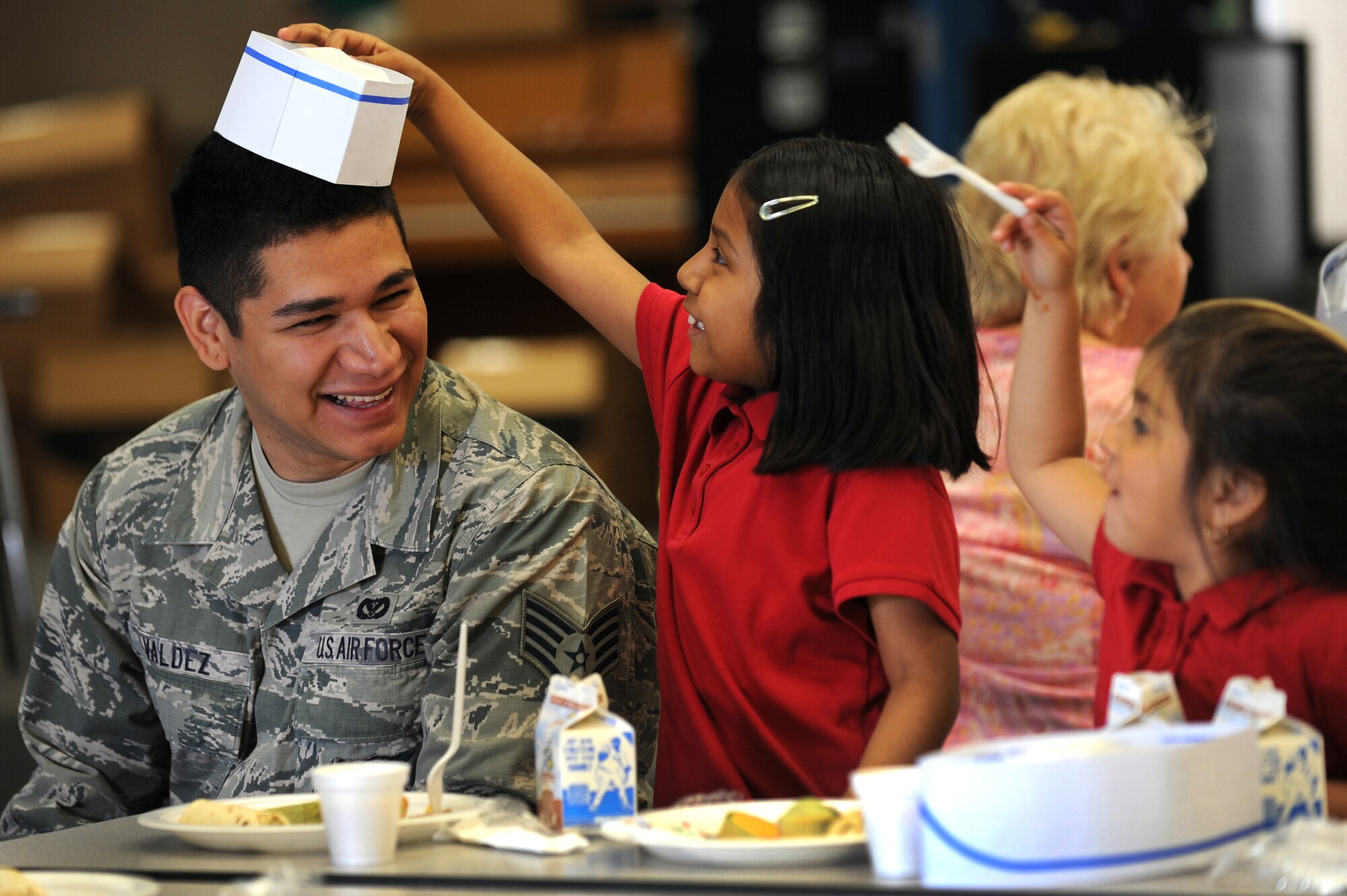 U.S. Air Force Staff Sgt. John Valdez, 99th Civil Engineer Squadron fire protection crew chief, spends time with students at a Chefs for Kids event May 3, 2012, at Rex Bell Elementary School in Las Vegas, Nev. Valdez and other volunteers helped set and serve the final breakfast of the year. (U.S. Air Force photo by Staff Sgt. William P.Coleman)
  

