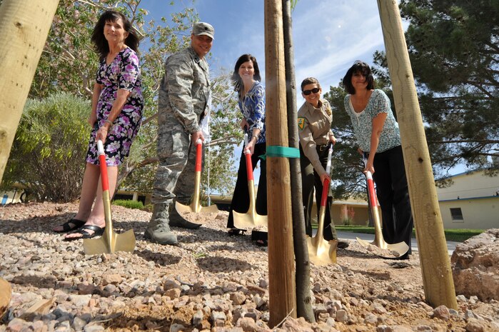 Debby Stockdale, 99th Civil Engineer Squadron chief of asset management, U.S. Air Force Lt. Col. Aaron Young, 99th CES commander, Tracie Dyer, Principal of Lomie  Heard Elementary School, Adria DeCorte, Nevada Division of Forestry park ranger, and Susan Breckon, Nellis Family Housing director, plant a tree during an Arbor Day ceremony at Lomie Heard Elementary School May 03, 2012, on Nellis Air Force Base, Nev. Nellis was acknowledged by the National Arbor Day Foundation for its beautiful trees and its continual dedication to environmental improvement. (U.S. Air Force photo by Airman 1st Class Daniel Hughes)