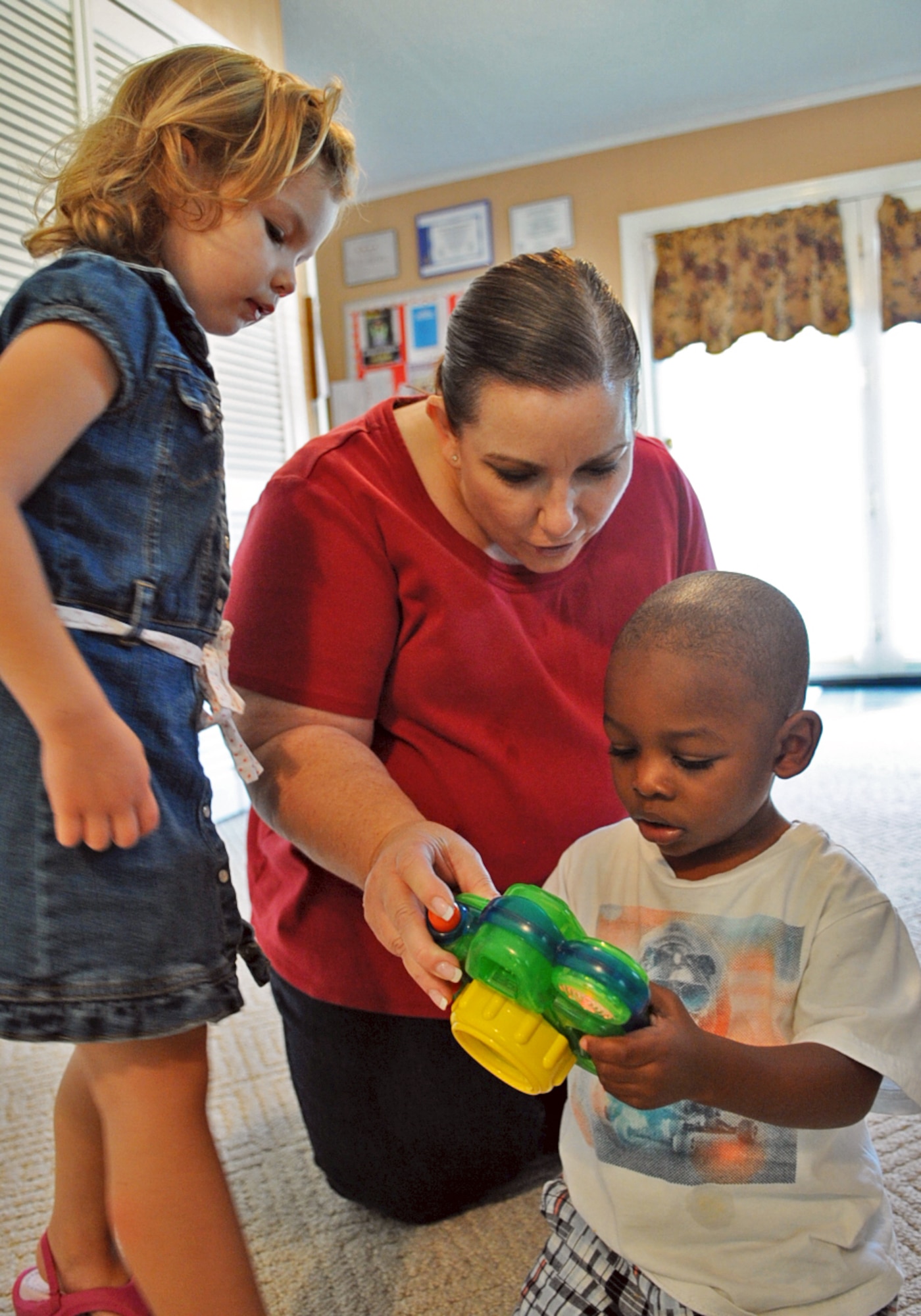 Toni Phaneuf explains to children how to use a toy camera during playtime at her home in Goldsboro, N.C., May 7, 2012. Toni finds that teaching children through play assists in better comprehension. Toni is the spouse of retired Tech. Sgt. Gary Phaneuf and hails from Mira Mesa, Calif. (U.S. Air Force photo/Airman 1st Class Aubrey Robinson/Released)