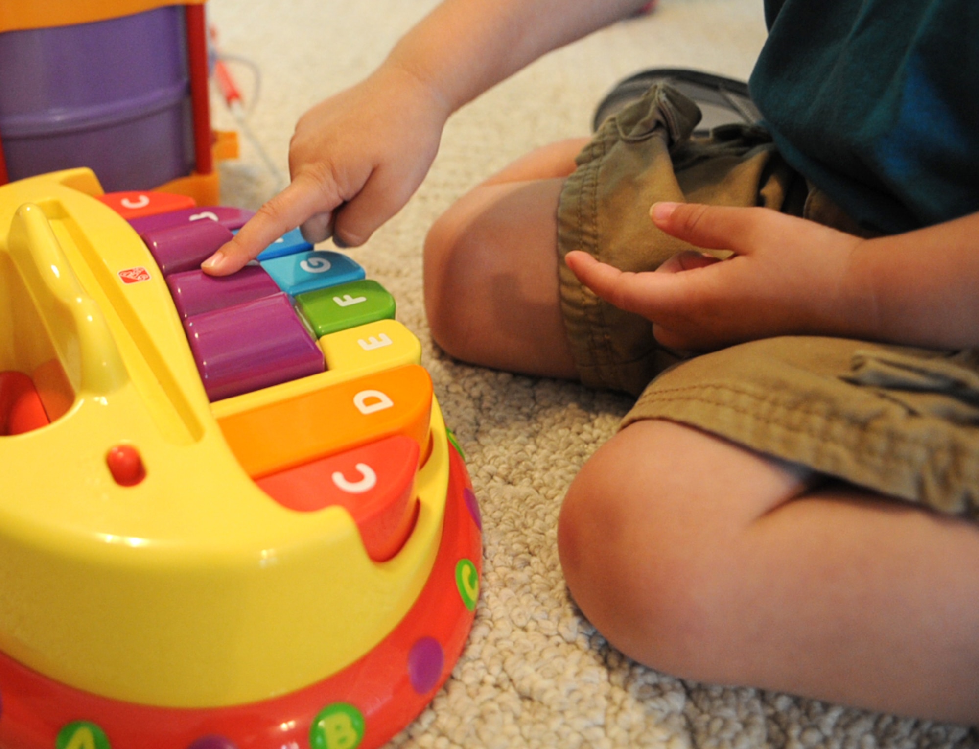 Ayden Ortiz, 2, plays with a toy piano while learning the alphabet at the Phaneuf residence in Goldsboro, N.C., May 7, 2012. When there is a limit on space and service hours at the child development center, home-based family child care providers are made available to fulfill the needs of children and parents. Ortiz is the son of Senior Airman Heber Ortiz, 334th Aircraft Maintenance Unit avionics specialist, and hails from Pueblo, Fla. (U.S. Air Force photo/Airman 1st Class Aubrey Robinson/Released)