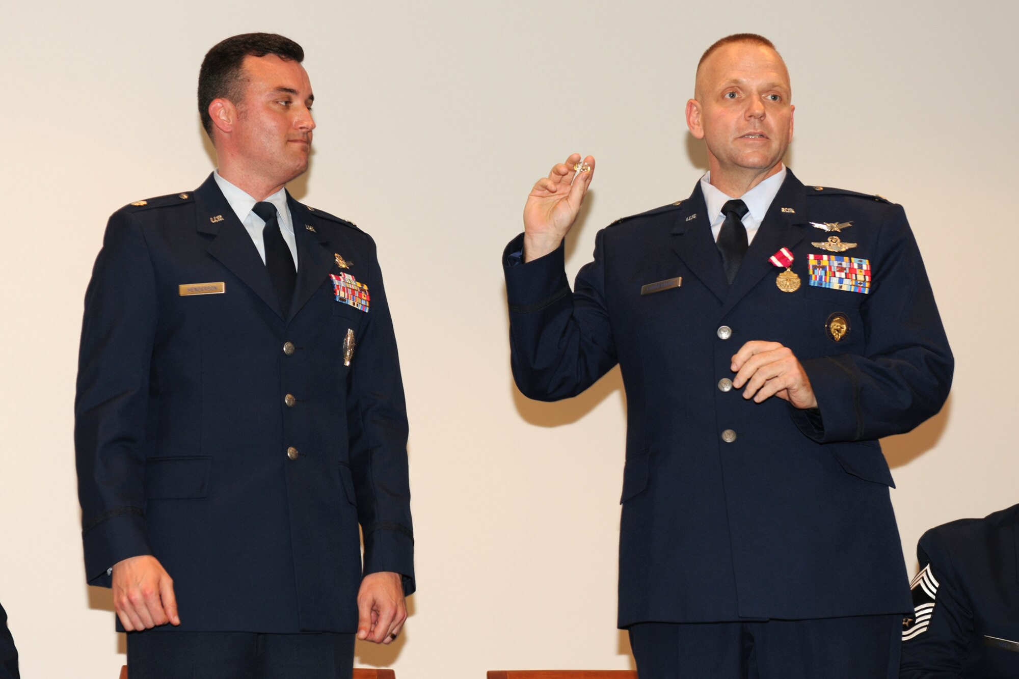 Lt. Col. Richard D. Henderson, right, the new commander of the 222nd Command and Control Squadron, receives a commander’s badge from former 222nd commander Col. Timothy T. Lunderman.(Photo by SSgt James Faso/Released)