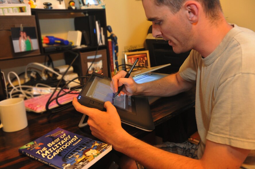 Capt. Timothy Tryon, 2nd Operations Support Squadron flight commander, draws his comic Crew Dogs at his home in Haughton, La., April 28. As a cartoonist, Tryon created Crew Dogs in 2007 and recently raised $600 through the comic's website for the Air Force Assistance Fund. (U.S. Air Force photo/Tech. Sgt. Mike Andriacco)