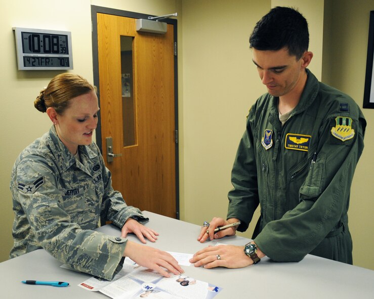 Airman 1st Class Jaymi Jeffrey, 2nd Operations Support Squadron intelligence analyst and unit Air Force Assistance Fund representative, explains the different AFAF charities to Capt. Timothy Tryon, 2 OSS flight commander, on Barksdale Air Force Base, La., April 27. Tryon, a cartoonist, raised $600 for the AFAF through sales of his comic, Crew Dogs. (U.S. Air Force photo/Senior Airman Sean Martin)