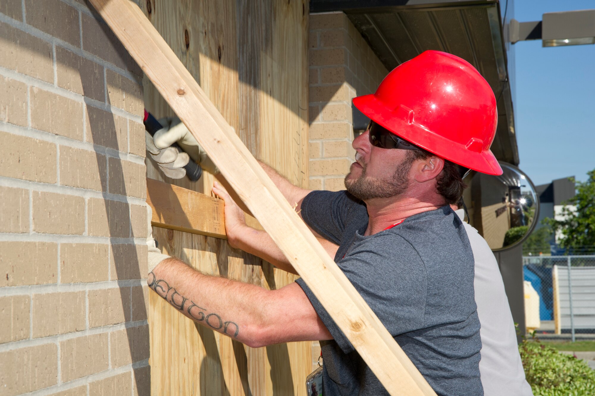 Dennis Johnson, CSC, secures boards protecting the front doors of the Fuels Management building during a hurricane condition Exercise April 25, 2012, at Keesler Air Force Base, Miss. The hardening exercise is in preparation for the 2012 hurricane season which runs from June 1 to Nov. 30.  (U.S. Air Force photo by Adam Bond)