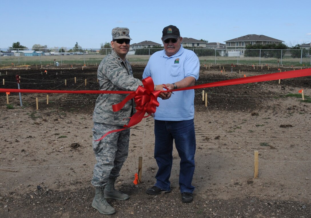 Maj. David Burnett, 28th Force Support Squadron commander, and Richard Nelson, 28th FSS Outdoor Recreation manager, cut a ribbon signifying the opening of the base garden plots at Ellsworth Air Force Base, S.D., May 8, 2012. The plots are located near Roosevelt Avenue near base housing and are available to rent through the outdoor recreation office. (U.S. Air Force photo by Airman 1st Class Anania Tekurio/Released)