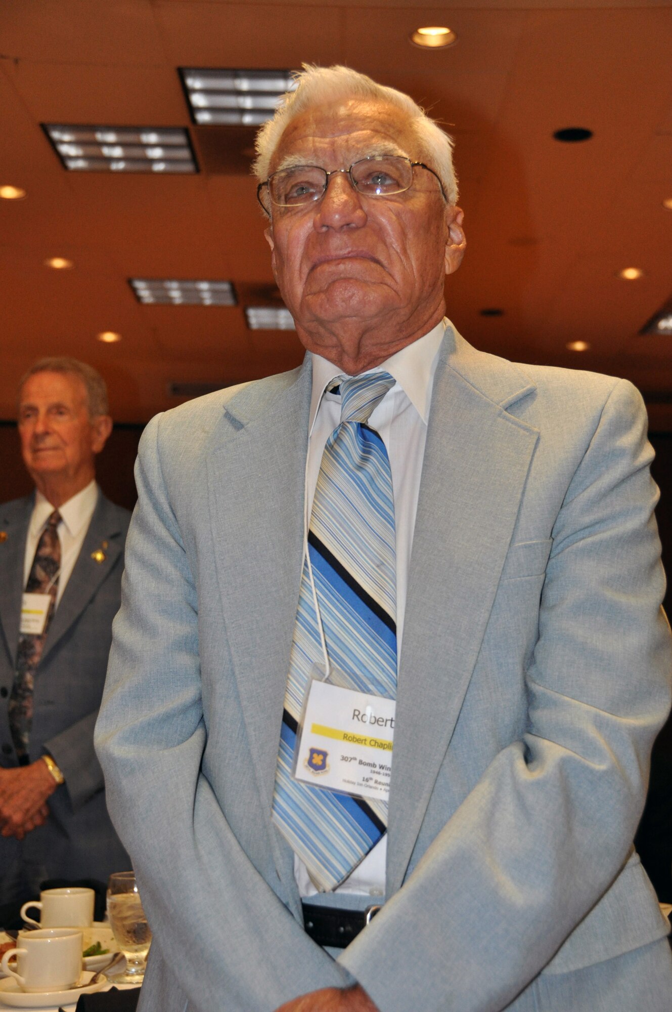 Robert Chaplin (foreground) and Cyrus Johnson (background) stood when their names were read as part of the list of Korean War veterans during the closing banquet of the 307th Bomb Wing/Group (1946-1954) Reunion held in Orlando, Fla., April 28, 2012. A representative from the 60th Anniversary of Korean War Commemoration Committee presented each of these individuals with a certificate of appreciation during the 16th reunion, which was held for former ground crew and flight crew members of the 307th and their families. (U.S. Air Force photo/Master Sgt. Mary Hinson)