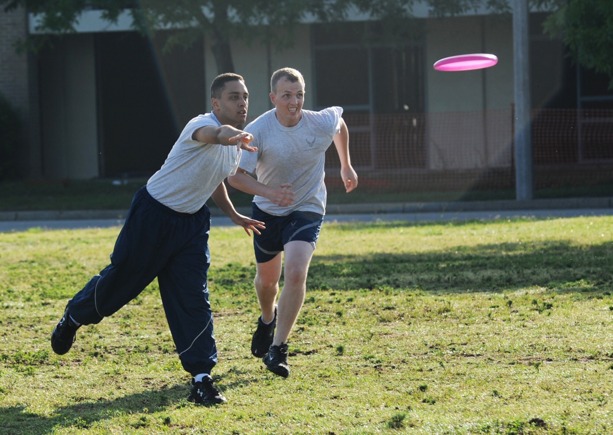 Second Lt. John Concepcion, Wing Staff Agency team, throws the frisbee to a team mate as Staff Sgt. Jeremiah Bowen runs up from the side in attempt to follow during an Ultimate Frisbee tournament for Sports Day May 4, 2012, at Keesler Air Force Base, Miss.  The 333rd defeated the WSA team, 6-1.  Sports Day was held in conjunction with May’s National Physical Fitness and Sports Month.   The event consisted of a variety of sports with participation from the many squadrons on base.  The winner of the small squadron division was 81st Training Support Squadron and the winner of the large squadron division was the 334th Training Squadron.  (U.S. Air Force photo by Kemberly Groue)