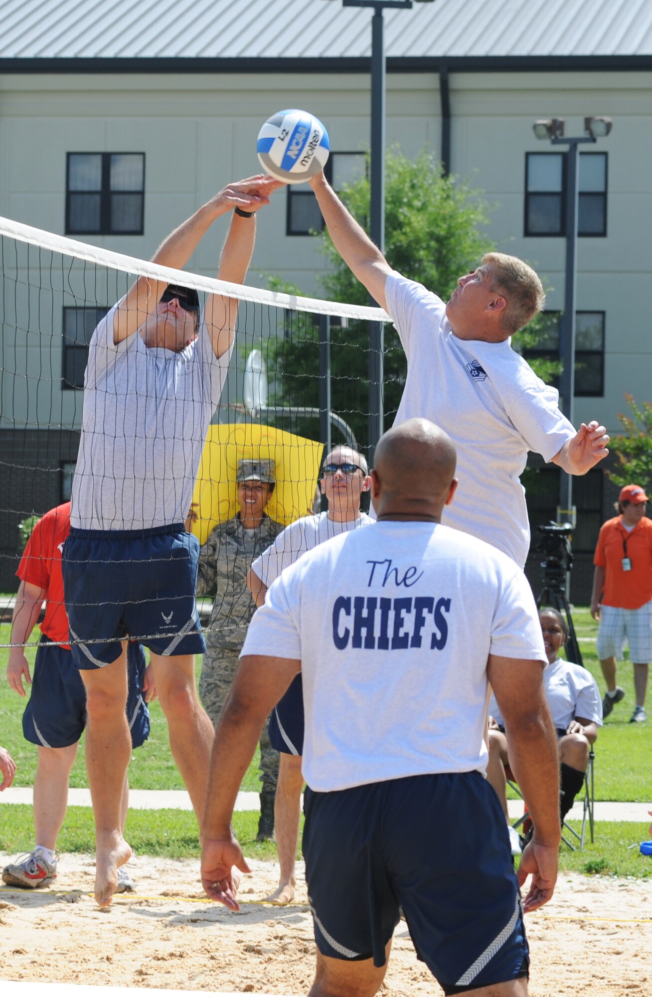 Brig. Gen. Andrew Mueller, 81st Training Wing commander, tips the ball over the net as Chief Master Sgt. Jeffery Bryant, 81st Security Forces Squadron, leaps to defend at a volleyball match between the commanders and the chiefs during Sports Day May 4, 2012, at Keesler Air Force Base, Miss.  The chiefs defeated the commanders.  Sports Day was held in conjunction with May’s National Physical Fitness and Sports Month.   The event consisted of a variety of sports with participation from the many squadrons on base.  The winner of the small squadron division was 81st Training Support Squadron and the winner of the large squadron division was the 334th Training Squadron.  (U.S. Air Force photo by Kemberly Groue)