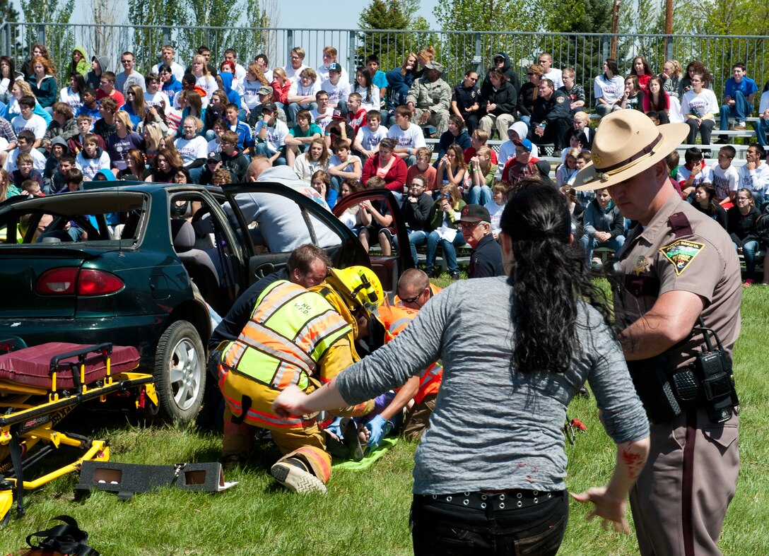 Law enforcement and first response specialists from the local area and state team up to safely extricate  a car crash victim during a simulated driving under the influence scenario at the Freshman Impact event at Douglas High School in Box Elder, S.D., May 7, 2012. Freshman Impact targets high school freshman, who don’t yet have driving privileges and is designed to educate them on the impact of a bad choice while drinking and driving. (U.S. Air Force photo by Airman 1st Class Kate Thornton/Released)