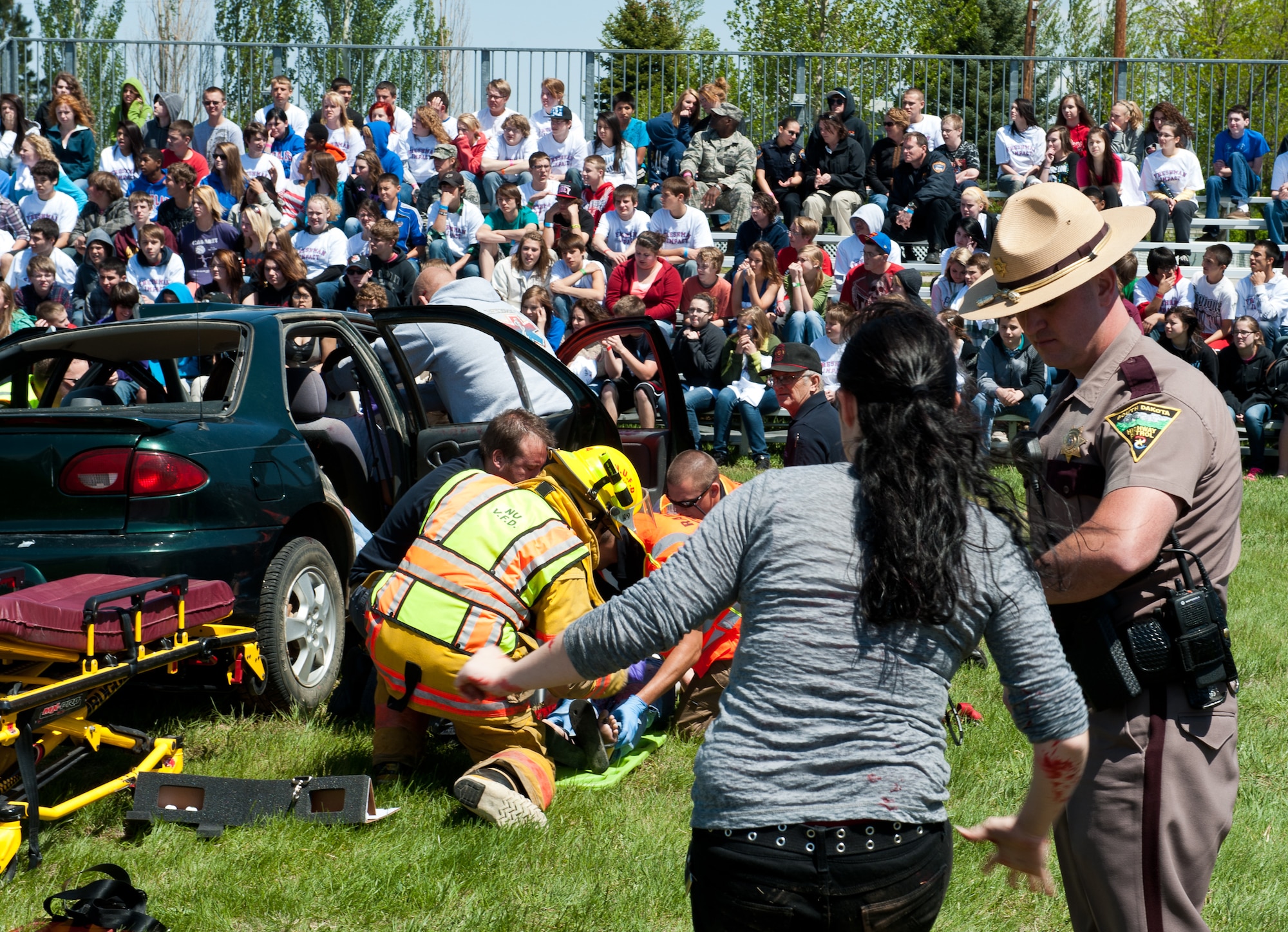 Law enforcement and first response specialists from the local area and state team up to safely extricate  a car crash victim during a simulated driving under the influence scenario at the Freshman Impact event at Douglas High School in Box Elder, S.D., May 7, 2012. Freshman Impact targets high school freshman, who don’t yet have driving privileges and is designed to educate them on the impact of a bad choice while drinking and driving. (U.S. Air Force photo by Airman 1st Class Kate Thornton/Released)