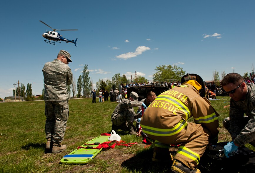 Airmen assigned to the 28th Medical Group ambulance services and 28th Civil Engineers Squadron fire protection administer care to a patient during a simulated driving under the influence scenario at the Freshman Impact event at Douglas High School in Box Elder, S.D., May 7, 2012. Ellsworth personnel used realistic demonstrations to help educate students on the results of poor choices while driving, including deciding to drink and drive. The demonstrations also gave base Airmen an opportunity to train on how to respond to a vehicle accident. (U.S. Air Force photo by Airman 1st Class Kate Thornton/Released)