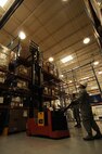 Senior Airman Brian Gratton, 50th Space Communications Squadron, uses a pallet stacker to remove a pallet of computer equipment off a shelf in the warehouse, while Airman 1st Class Napoleon Tavale III, 50 SCS,  spots him at the Base Equipment Control Office May 8. Both are members of BECO an office which controls an estimated $19 million worth of information technology equipment. (U.S. Air Force photo/Staff Sgt. Patrice Clarke)