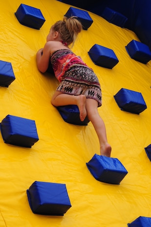 Ava Fuenffinger climbs an inflatable rock wall during the Joint Base Charleston Annual Picnic, May 4. The picnic was held to show appreciation for Team Charleston members. Ava's father is Staff Sgt. Paul Fuenffinger, 628th Logistics Readiness Squadron. (U.S. Air Force photo/Airman 1st Class Chacarra Walker)