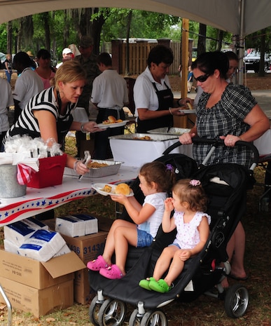 Servers from Jim-N-Nicks restaurant serve Airmen and their families at the Joint Base Charleston Annual Picnic, May 4. The two-day event included activities for adults and children, free food, live entertainment, a water slide and several giant inflatables for children to play on. (U.S. Air Force photo/Airman 1st Class Chacarra Walker)