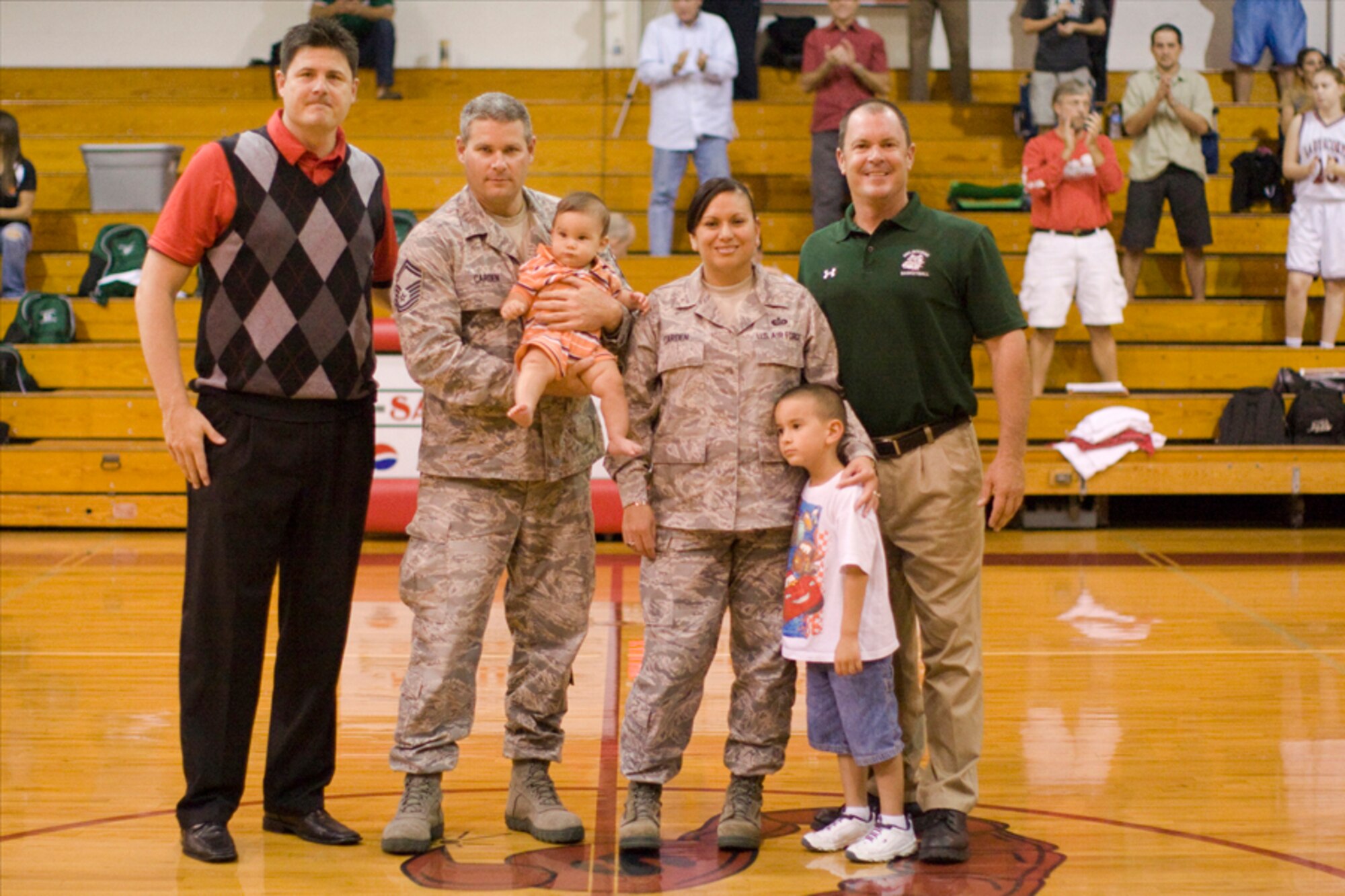 Tech. Sgt. Nikki Carden, her husband Senior Master Sgt. David Carden and their two boys were honored for their involvement in the local community during a varsity girl's basketball game at Satellite High School, Satellite Beach, Fla., Dec. 2011. Nikki's most recent involvement with the community brought awareness to breast cancer with the Relay for Life.  (Courtesy photo)
