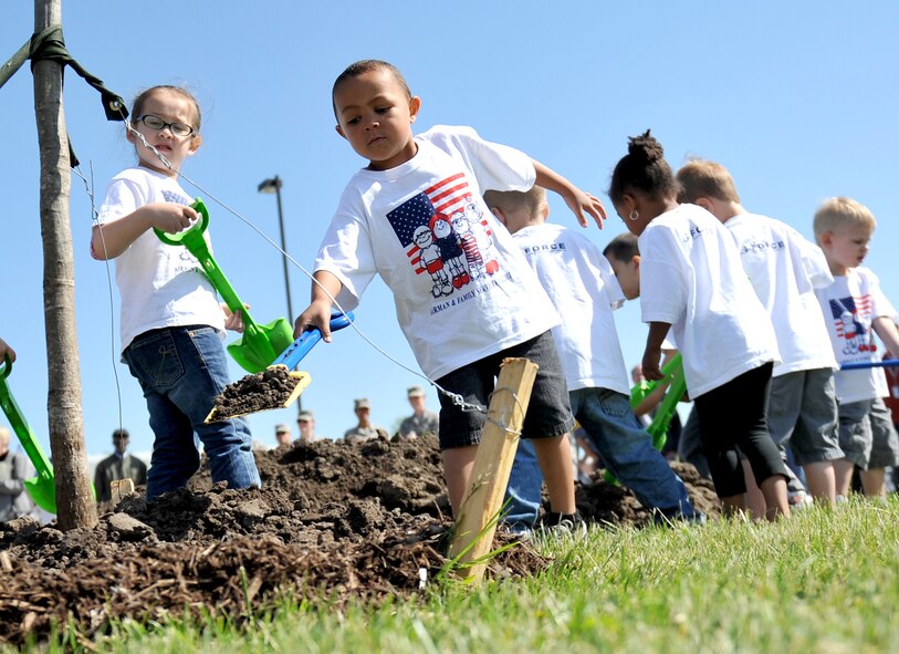 (Left to Right) Sydney Pontious looks over Kobly Johnson while he carefully places dirt around the tree with a little help from Maliyah Parker and Jack Duncan covering the newly planted Northern Red Oak tree in front of Child Development Center II on Offutt Air Force Base, Neb., April 26 in celebration of Arbor Day. Offutt has been named Tree City USA for the last 22 years by the Arbor Day Foundation. (U.S. Air Force photo by Jeff W. Gates/Released)