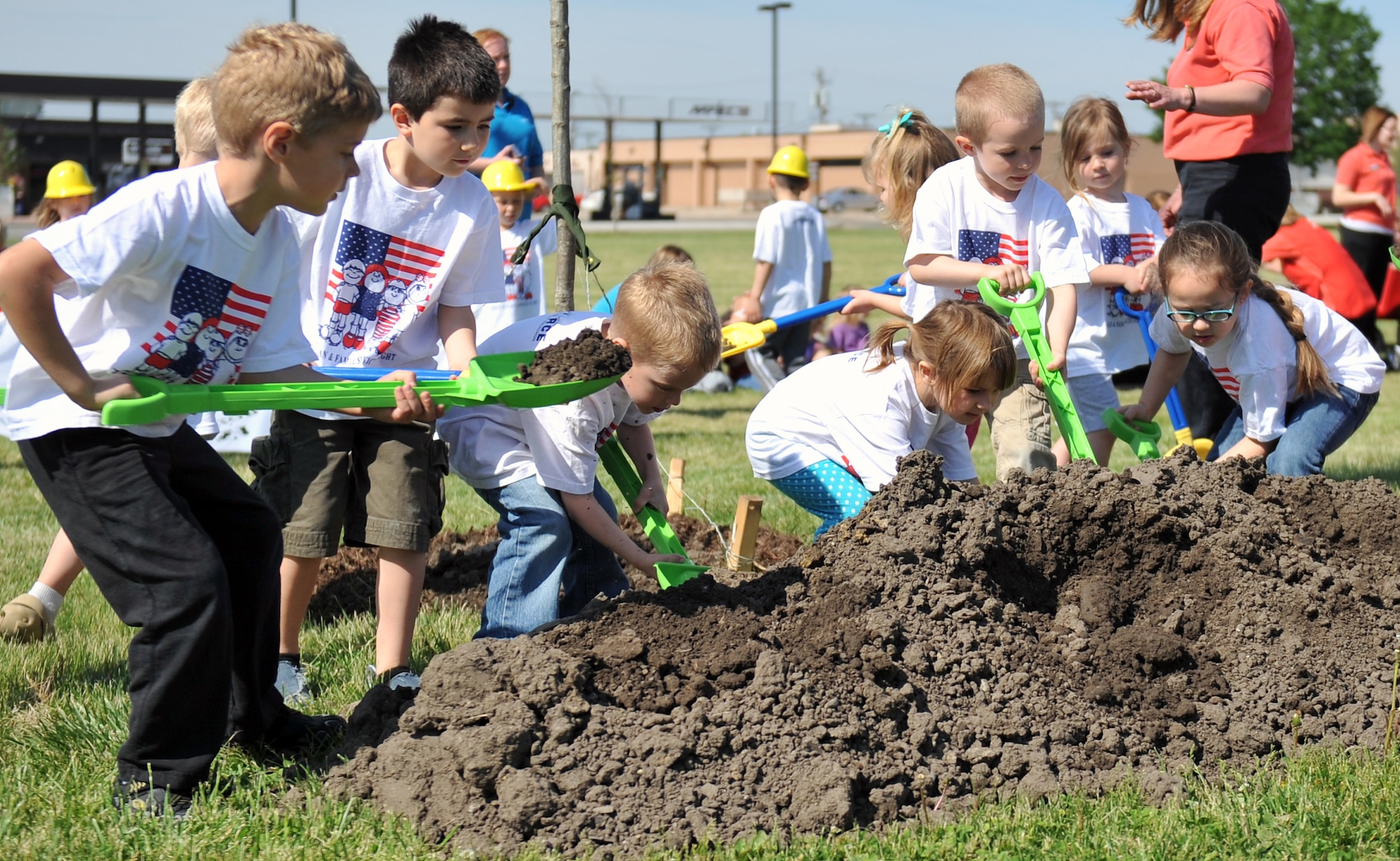 (Left to Right) Brenden Cunningham, Same Tebo, Jake Person, Alyssa Moses, Addyson Jacobson, Donavan Ayers, Emma Meggison and Sydeny Pontious dig for the newly planted Northern Red Oak tree in front of Child Development Center II on Offutt Air Force Base, Neb., April 26 in celebration of Arbor Day. Offutt has been named Tree City USA for the last 22 years by the Arbor Day Foundation. (U.S. Air Force photo by Jeff W. Gates/Released)