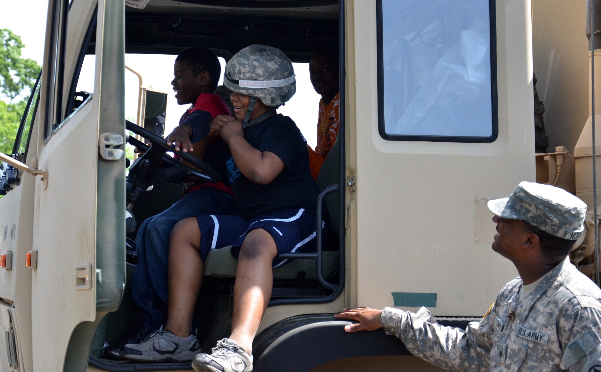 U.S. Army Sgt. Christopher Hitchman, 689th Rapid Port Opening Element forward distribution node NCOIC, helps local students explore the Heavy Expanded Mobility Tactical Truck Load Handling System during the Newport News Public Schools' George Green 41st Annual Special Education Field Day at Todd Stadium in Newport News, Va., May 1. In addition to a variety of competitions and games, 698th RPOE Soldiers provided tours of vehicles and equipment, and answered questions from students. (U.S. Army photo by Michelle Montieth/Released)
