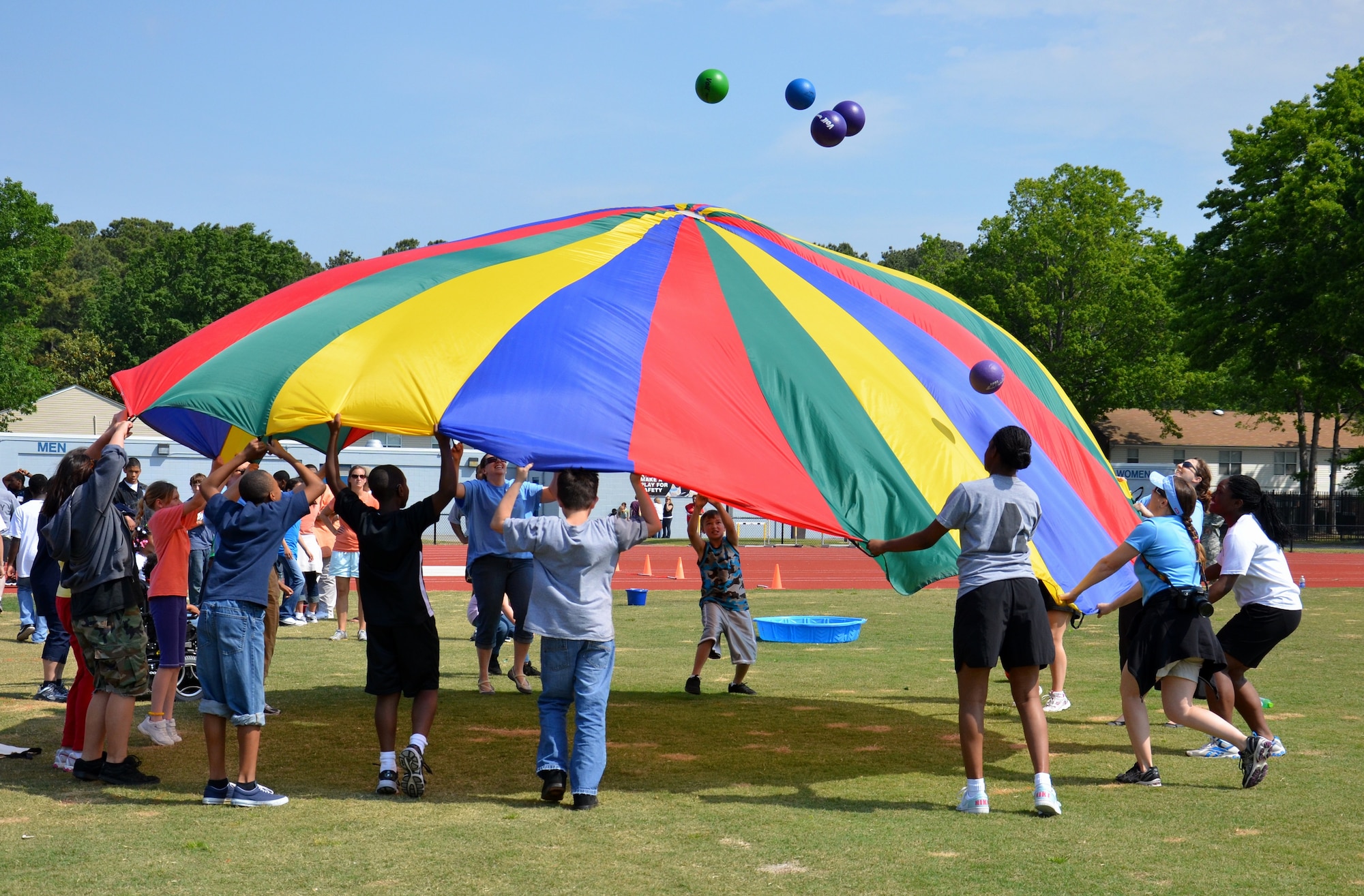 Soldiers from the 689th Rapid Port Opening Element join local students in a game of “parachute pop” during the Newport News Public Schools' George Green 41st Annual Special Education Field Day at Todd Stadium in Newport News, Va., May 1. The event included more than 150 students with special needs from across the school district. (U.S. Army photo by Michelle Montieth/Released)