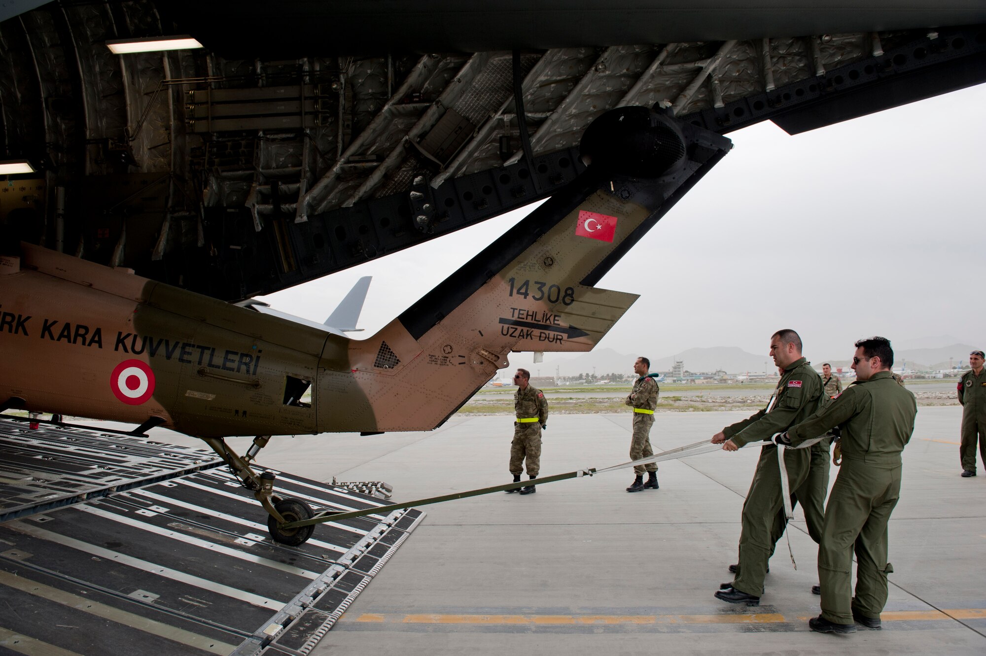 Turkish air force members pull a TURAF UH-60 Black Hawk helicopter from the back of a U.S. Air Force C-17 Globemaster III May 5, 2012, at Kabul International Airport, Afghanistan. The C-17 aircrew from Joint Base McGuire-Dix-Lakehurst, N.J., transported the helicopter to Kabul from Incirlik Air Base, Turkey. The joint support mission provided smooth delivery of the helicopter to replace one that crashed December 2011. (U.S. Air Force photo by Senior Airman Anthony Sanchelli/Released)