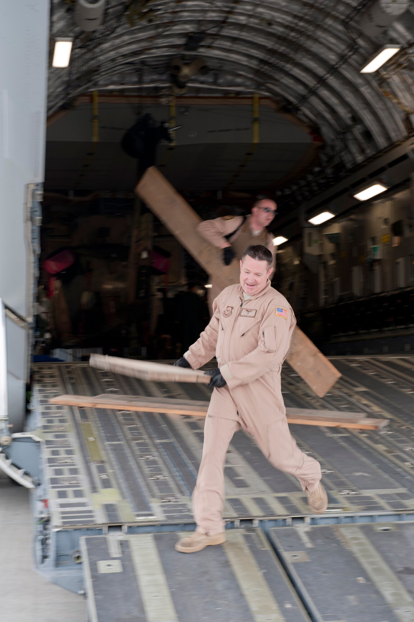 Tech. Sgt. Michael Ferguson and Staff Sgt. Micah Hackett, 6th Airlift Squadron loadmasters, unload wooden planks from the back of a C-17 Globemaster III May 5, 2012, at Kabul International Airport, Afghanistan. The C-17 aircrew from Joint Base McGuire-Dix-Lakehurst, N.J., transported a Turkish air force UH-60 Black Hawk helicopter to Kabul from Incirlik Air Base, Turkey. The joint support mission provided smooth delivery of the helicopter to replace one that crashed December 2011. (U.S. Air Force photo by Senior Airman Anthony Sanchelli/Released)