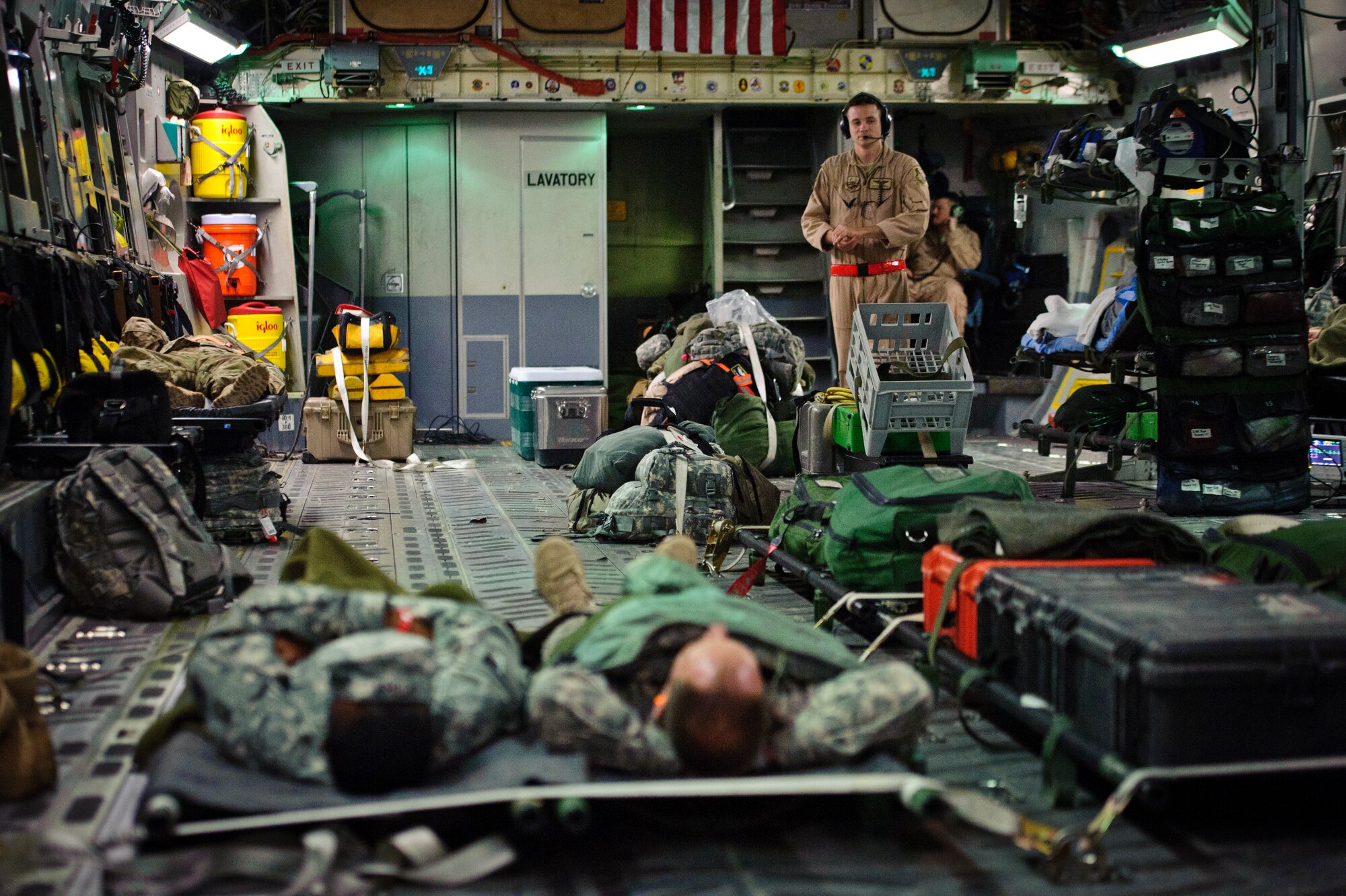 SOUTHWEST ASIA – Patients rest as Tech. Sgt. Travis Shore, 379th Expeditionary Aeromedical Evacuation Squadron medical technician, watches over them during an evacuation flight to Landstuhl Regional Medical Center, Germany, April 25, 2012. (U.S. Air Force photo/Staff Sgt. Nathanael Callon)