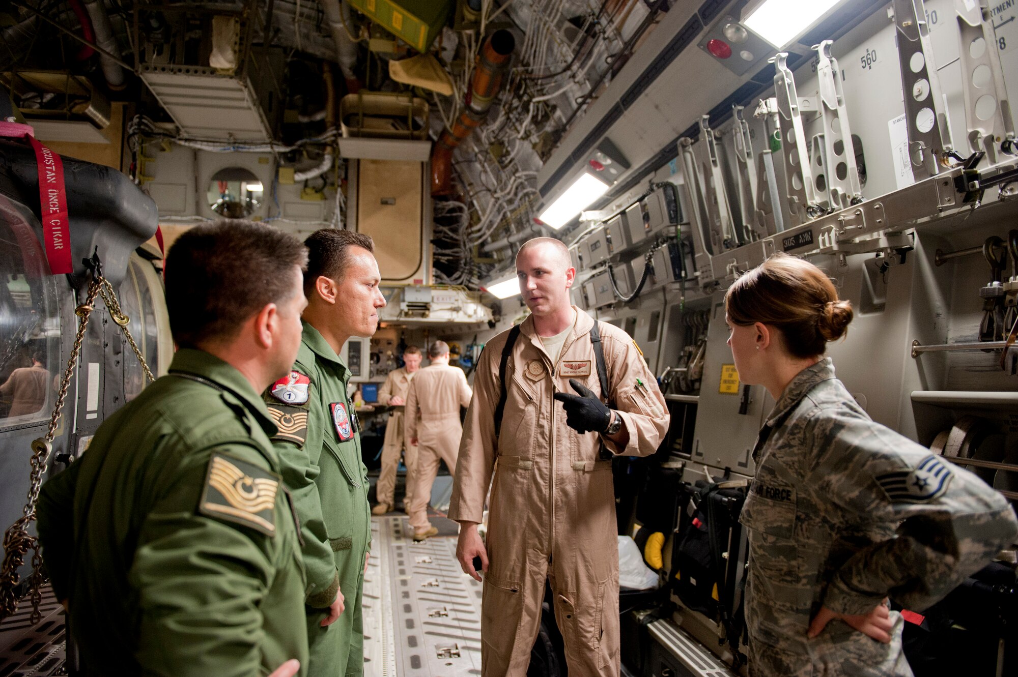 Staff Sgt. Micah Hackett, 6th Airlift Squadron loadmaster, second from right, gives a safety briefing to two Turkish air force UH-60 Black Hawk helicopter pilots, left, and Staff Sgt. Lana Mills, 39th Air Base Wing Public Affairs broadcaster, right, on a C-17 Globemaster III May 3, 2012, at Incirlik Air Base, Turkey. The C-17 aircrew from Joint Base McGuire-Dix-Lakehurst, N.J., transported a TURAF helicopter to Kabul, Afghanistan, May 5, 2012. The joint support mission provided smooth delivery of the helicopter to replace one that crashed December 2011. (U.S. Air Force photo by Senior Airman Anthony Sanchelli/Released)