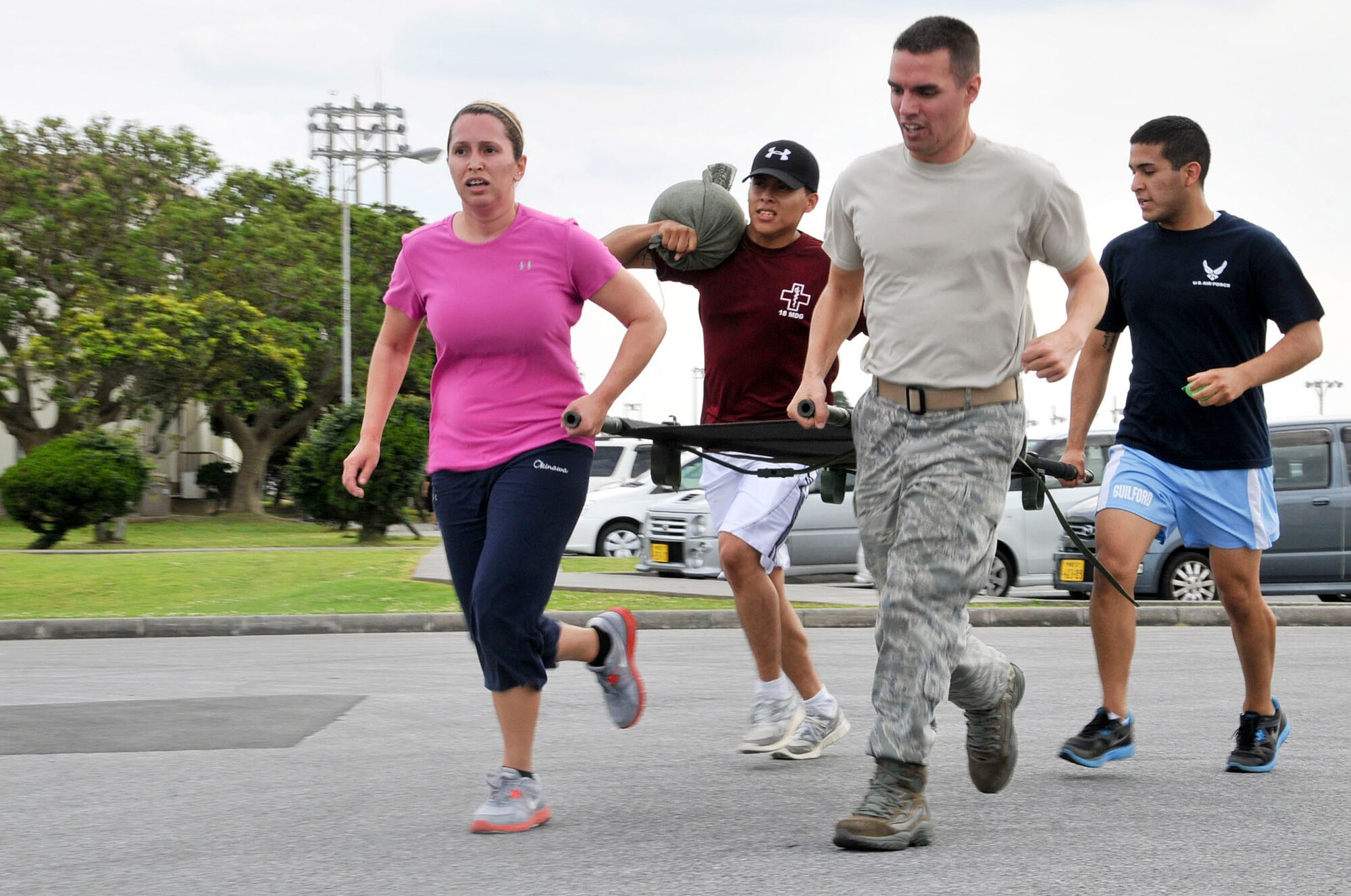 Family Medicine (Team 1) races to the finish line holding various items during the "Amazing Race" obstacle course held to honor nurses around the world May 8, at Kadena Air Base, Japan. The teams had to carry a litter and received two water balloons for every correct answer, one for answering a bonus question and one sandbag for every wrong answer. Keeping a water balloon intact to the finishing point took 30 seconds off the team's total time. Starting on National Nurse Day, May 6, through the birthday of famous nurse pioneer Florence Nightingale, May 12, events are held to honor nurses around the world. (U.S. Air Force photo/Staff Sgt. Darnell T. Cannady)  