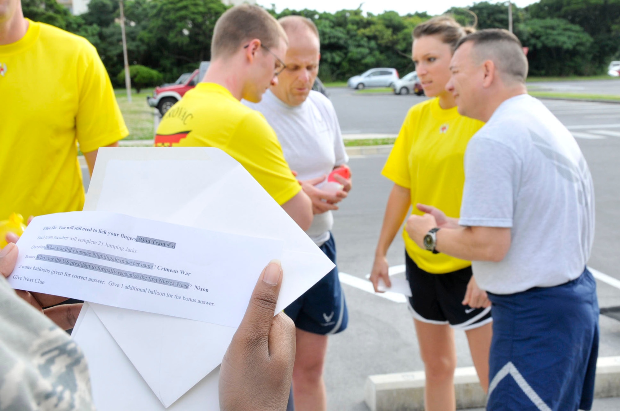 Aeromedical Evacuation Squadron (Team 2) holds a team discussion before answering their question during the amazing race obstacle course to honor nurses around the world May 8, at Kadena Air Base, Japan. Five teams raced to five stations where they had to perform an exercise and answer a question about nursing before receiving a clue for the next location. This year Kadena's medical staff jointly celebrated the event with the Camp Lester Naval Hospital medical staff. Starting on National Nurse Day, May 6, through the birthday of famous nurse pioneer Florence Nightingale, May 12, events are held to honor nurses around the world. (U.S. Air Force photo/Staff Sgt. Darnell T. Cannady)  