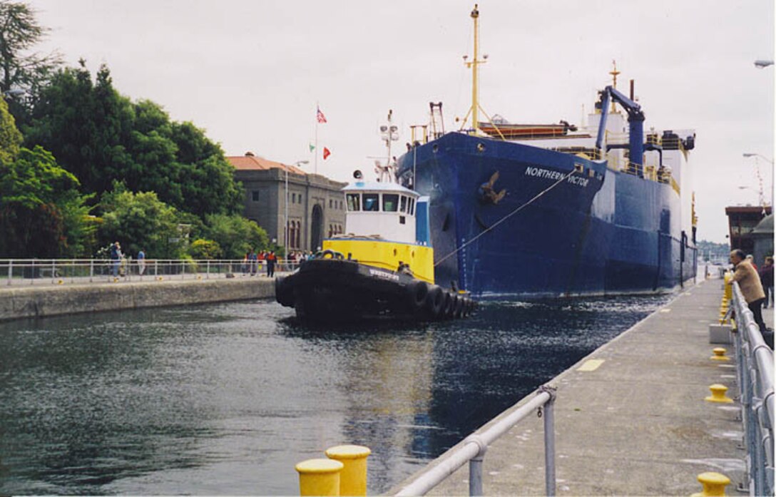 A tug pulls a fishing vessel through the large lock chamber at the Hiram M. Chittenden Locks in Seattle's Ballard neighborhood.