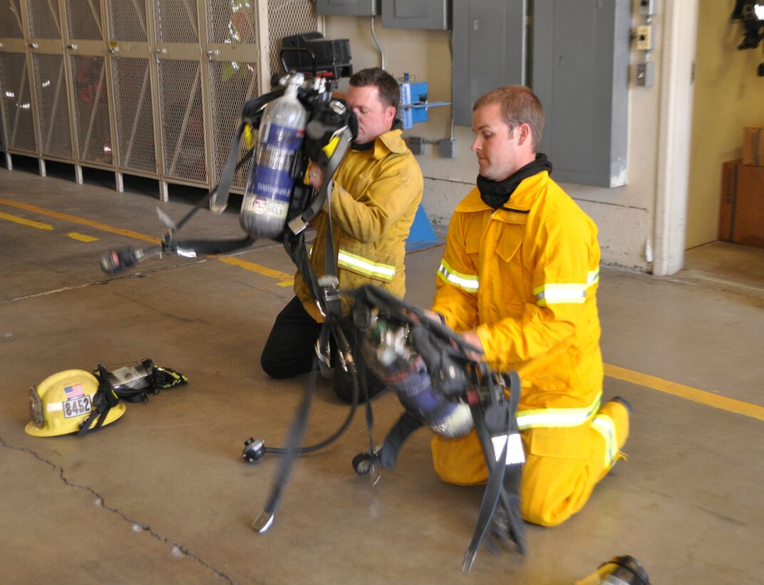 Agent Jeff Swearingen (right) with the Criminal Investigation Division of the Police Department aboard Marine Corps Logistics Base Barstow and Fire Prevention Officer Gabriel Hammett, with the Fire Department aboard MCLB Barstow, don their self-contained breathing apparatus during a cross-training session at the main fire station aboard the base May 9.