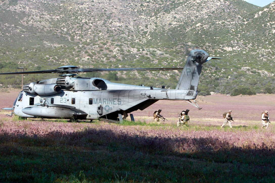 The Tactical Recovery of Aircraft and Personnel Platoon exits a CH-53E Super Stallion before recovering a downed pilot, as a part of a scenario-based training, here, May 9. The training was conducted as a part of the ground portion of Realistic Urban Training, an exercise designed to prepare the 15th Marine Expeditionary Unit for their upcoming deployment scheduled for this fall.