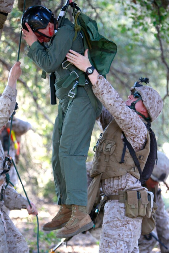 A Marine with the Tactical Recovery of Aircraft and Personnel Platoon, 15th Marine Expeditionary Unit, lowers Cpl. Brittany L. Jones from a tree during training, here, May 9. Jones was playing the role of a downed pilot during a TRAP mission. The training was conducted as a part of the ground portion of Realistic Urban Training, an exercise designed to prepare the 15th MEU for their upcoming deployment scheduled for this fall. Jones, 25, is a radio operator with the unit and hails from Elizabethtown, N.C.