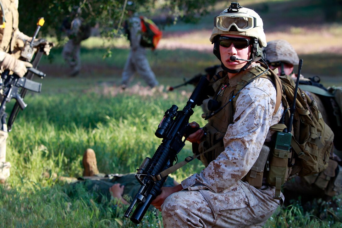 Lance Cpl. Joseph A. Ferguson, Tactical Recovery of Aircraft and Personnel Platoon, 15th Marine Expeditionary Unit, provides security for Cpl. Brittany L. Jones who was being escorted back to the helicopter during training, here, May 9. Jones was playing the role of a downed pilot during a TRAP mission. The training was conducted as a part of the ground portion of Realistic Urban Training, an exercise designed to prepare the 15th MEU for their upcoming deployment scheduled for this fall. Jones, 25, a native of Elizabethtown, N.C., is a radio operator with the unit and Ferguson, 20, is a native of Brentwood, Calif., and serves as a fire support man.