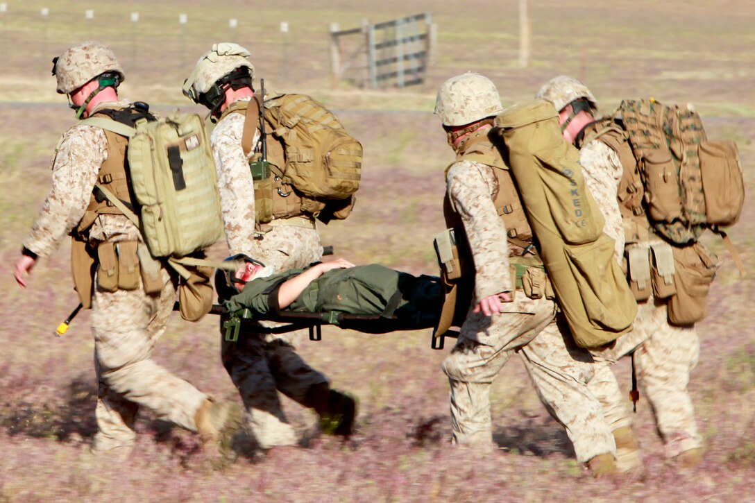 Marines and a Navy corpsman with the Tactical Recovery of Aircraft and Personnel Platoon, 15th Marine Expeditionary Unit, carry Cpl. Brittany L. Jones back to the helicopter during training, here, May 9. Jones was playing the role of a downed pilot during a TRAP mission. The training was conducted as a part of the ground portion of Realistic Urban Training, an exercise designed to prepare the 15th MEU for their upcoming deployment scheduled for this fall. Jones, 25, is a native of Elizabethtown, N.C., and is a radio operator with the unit.