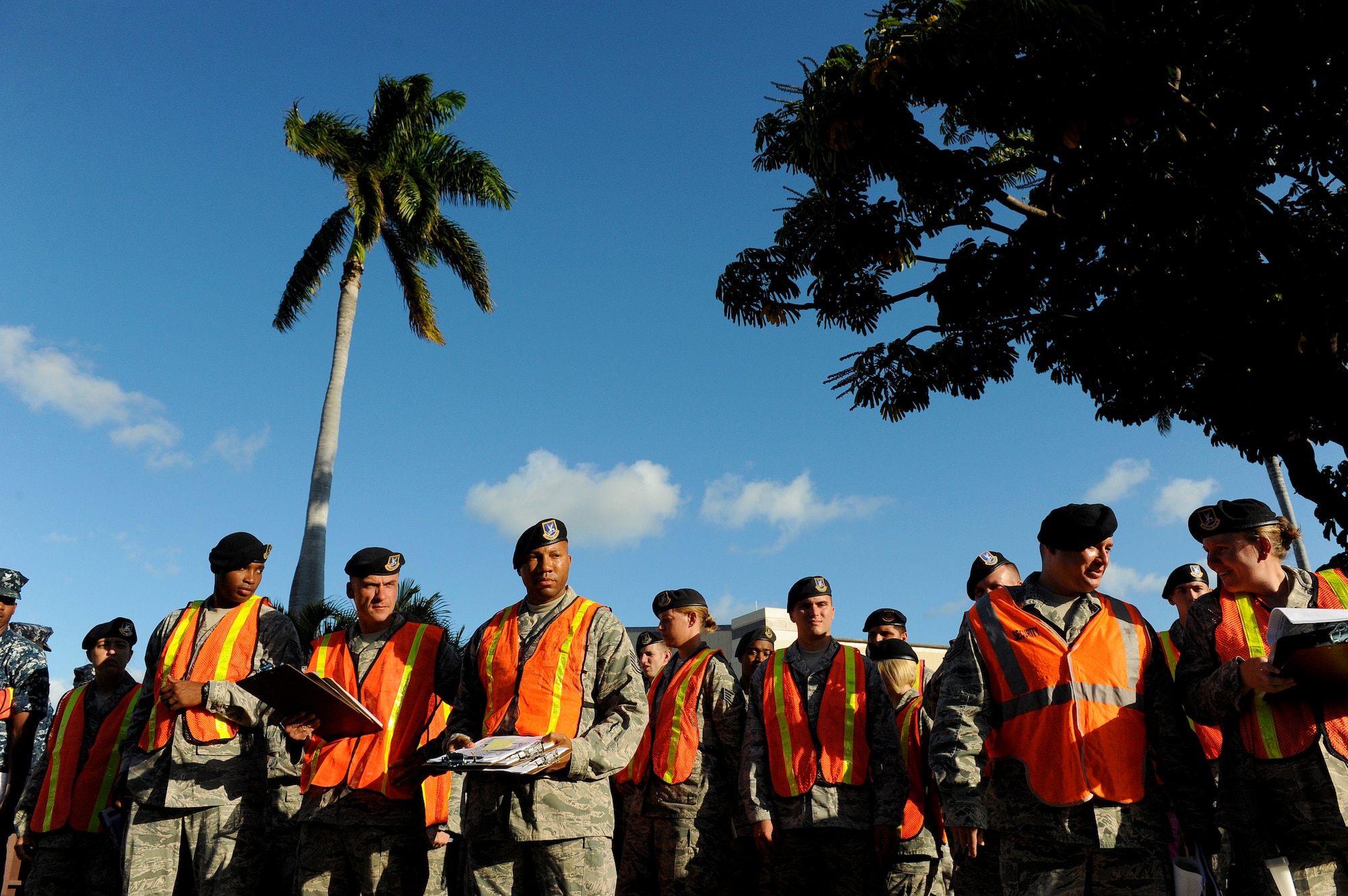 Airmen and Sailors wait for their names to be called during role call at the beginning of Operation ENLIGHTEN II, May 9, where Airmen and Sailors went to more than 2,000 homes to hand out information about safety and security. In response to a rash of crimes ranging from petty theft to grand larceny, Joint Base Pearl Harbor-Hickam officials engaged residents in the anti-crime campaign. More than 120 volunteers went door-to-door during the blitz event. (U.S. Air Force photo/Staff Sgt. Mike Meares)