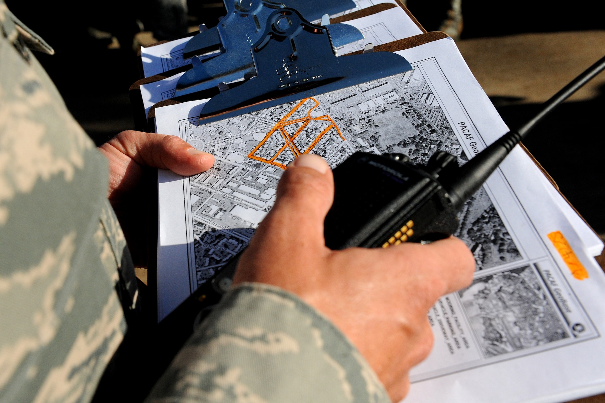 Master Sgt. Jeremy Isaac, 647th Security Forces Squadron, reviews a map of a housing area on Hickam Field where his team went door-to-door to hand out information about safety and security during Operation ENLIGHTEN II, May 9. In response to a rash of crimes ranging from petty theft to grand larceny, Joint Base Pearl Harbor-Hickam officials engaged residents in the anti-crime campaign. (U.S. Air Force photo/Staff Sgt. Mike Meares)