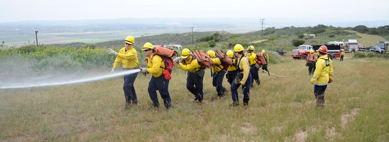 VANDENBERG AIR FORCE BASE, Calif. -- Evan Bolles, a 30th Civil Engineer Squadron Hot Shots instructor, walks a group of firefighting students up a firebreak teaching progressive hose lay techniques here Tuesday, May 1, 2012. Vandenberg AFB is the only Department of Defense installation that provides wildland firefighter training.  