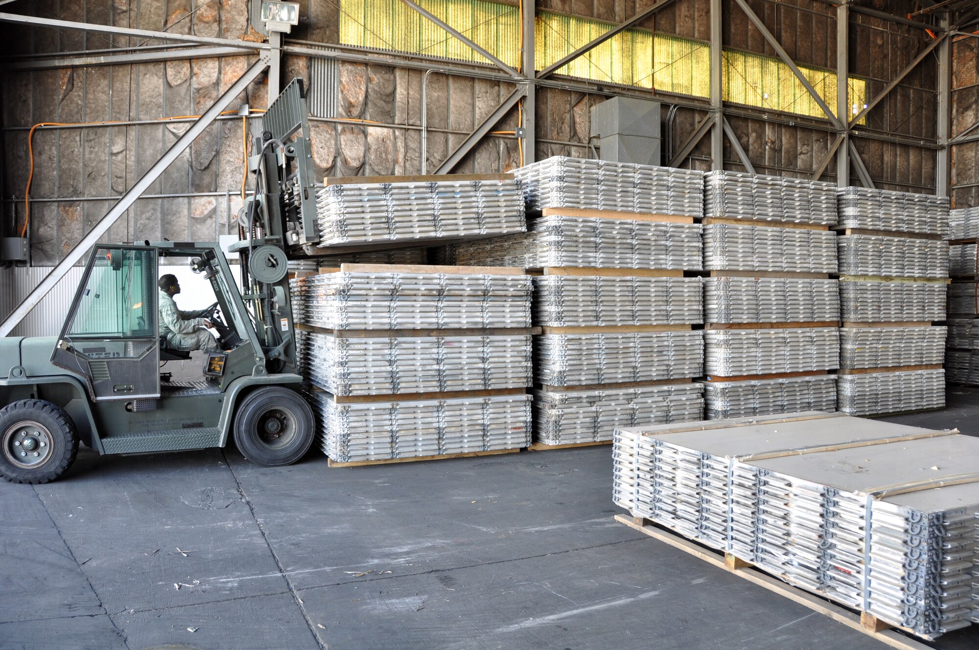 Senior Airman Richard Hunter, 60th Ariel Port Squadron air transportation specialist, uses a forklift to move cargo pallets Tuesday in the hangar they are stored in. (U.S. Air Force photo/ Staff Sgt. Patrick Harrower)